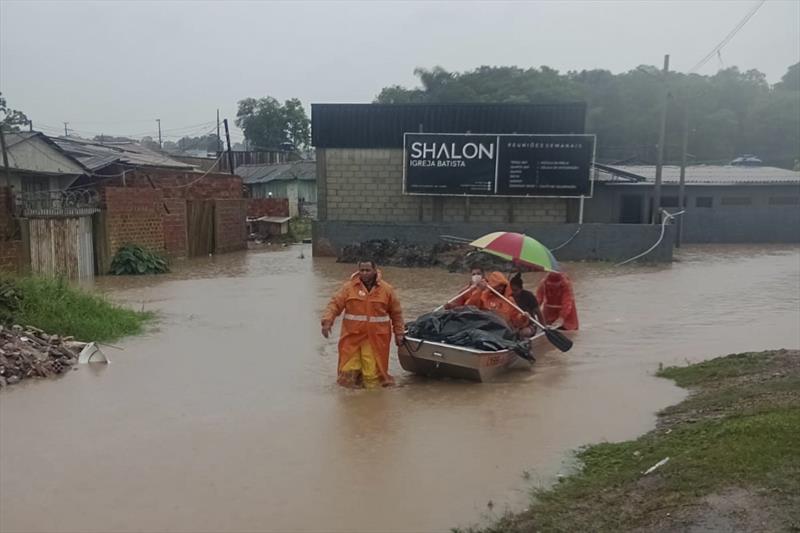 Tempestade em Curitiba causa alagamentos, e famílias têm resgate com barco