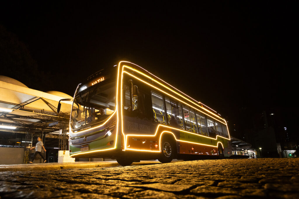 Ônibus elétrico iluminado circula pelas ruas de Curitiba